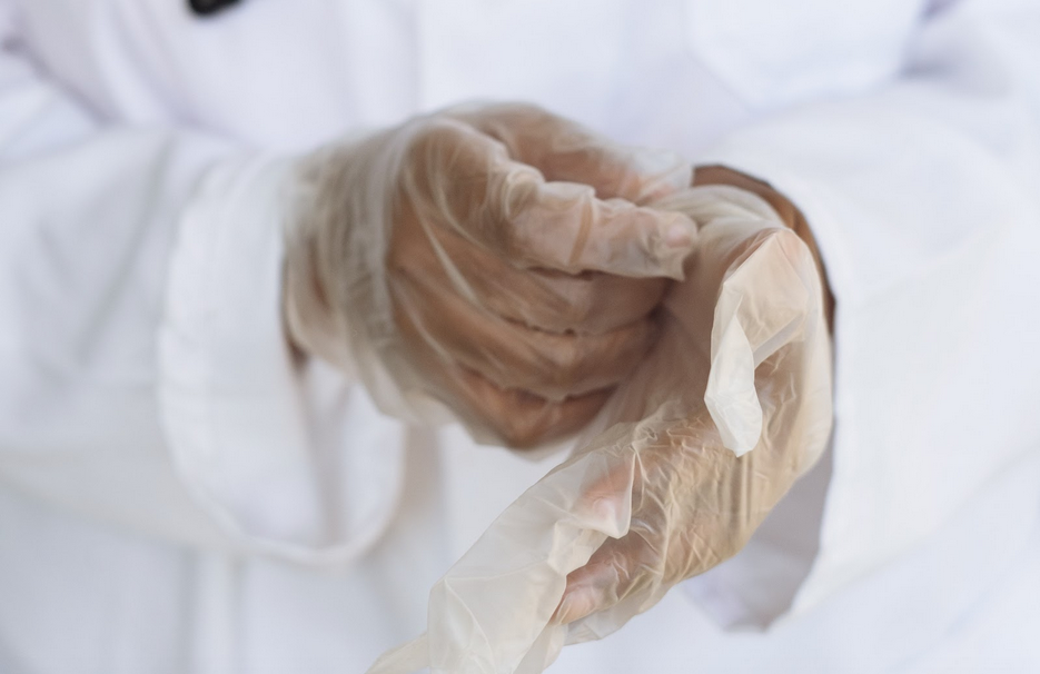 Doctor changing gloves before test post-mortem exam