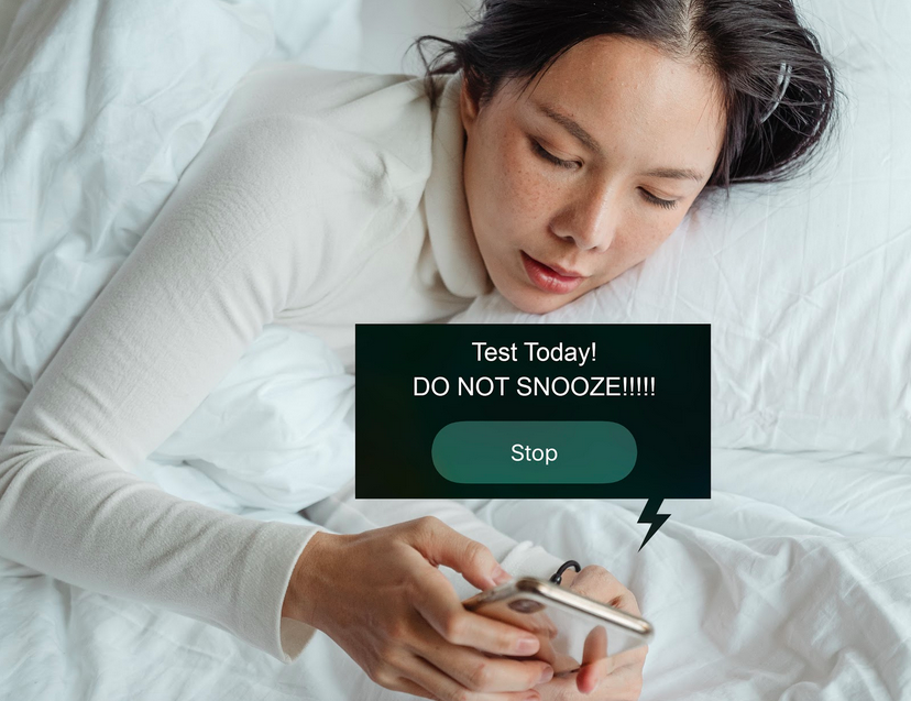 Woman in bed holding phone with message that says test today