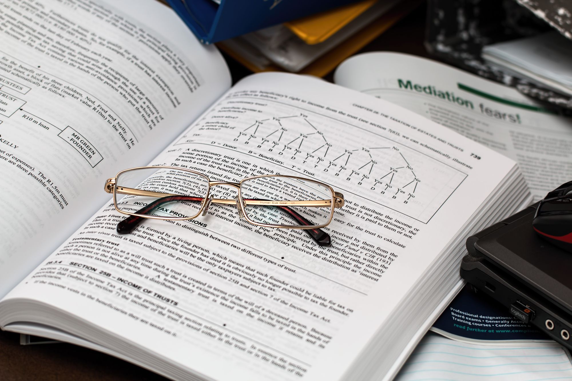 Course book with glasses on top of it