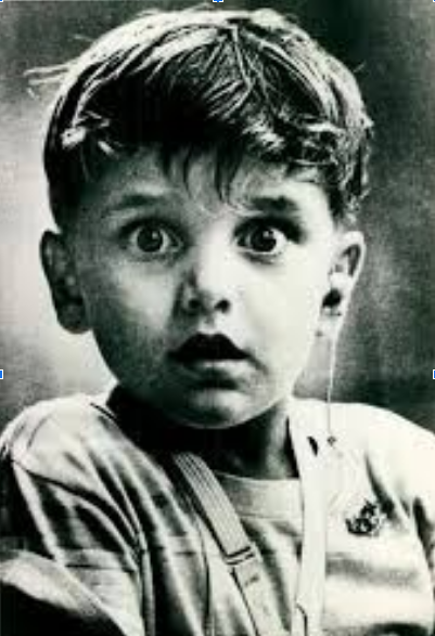 Boy with hearing aid looking surprised