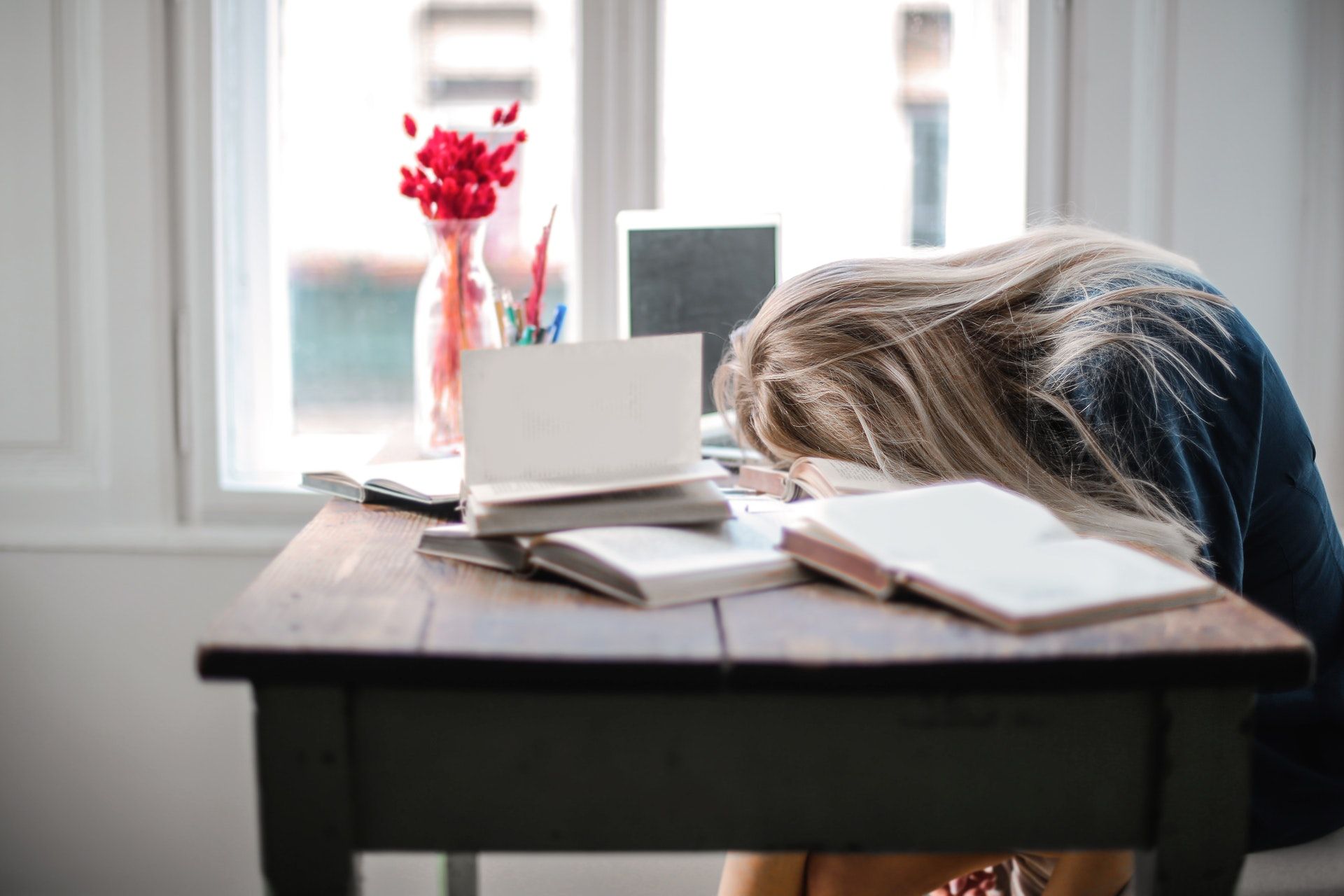 Girl sleeping on her desk and books