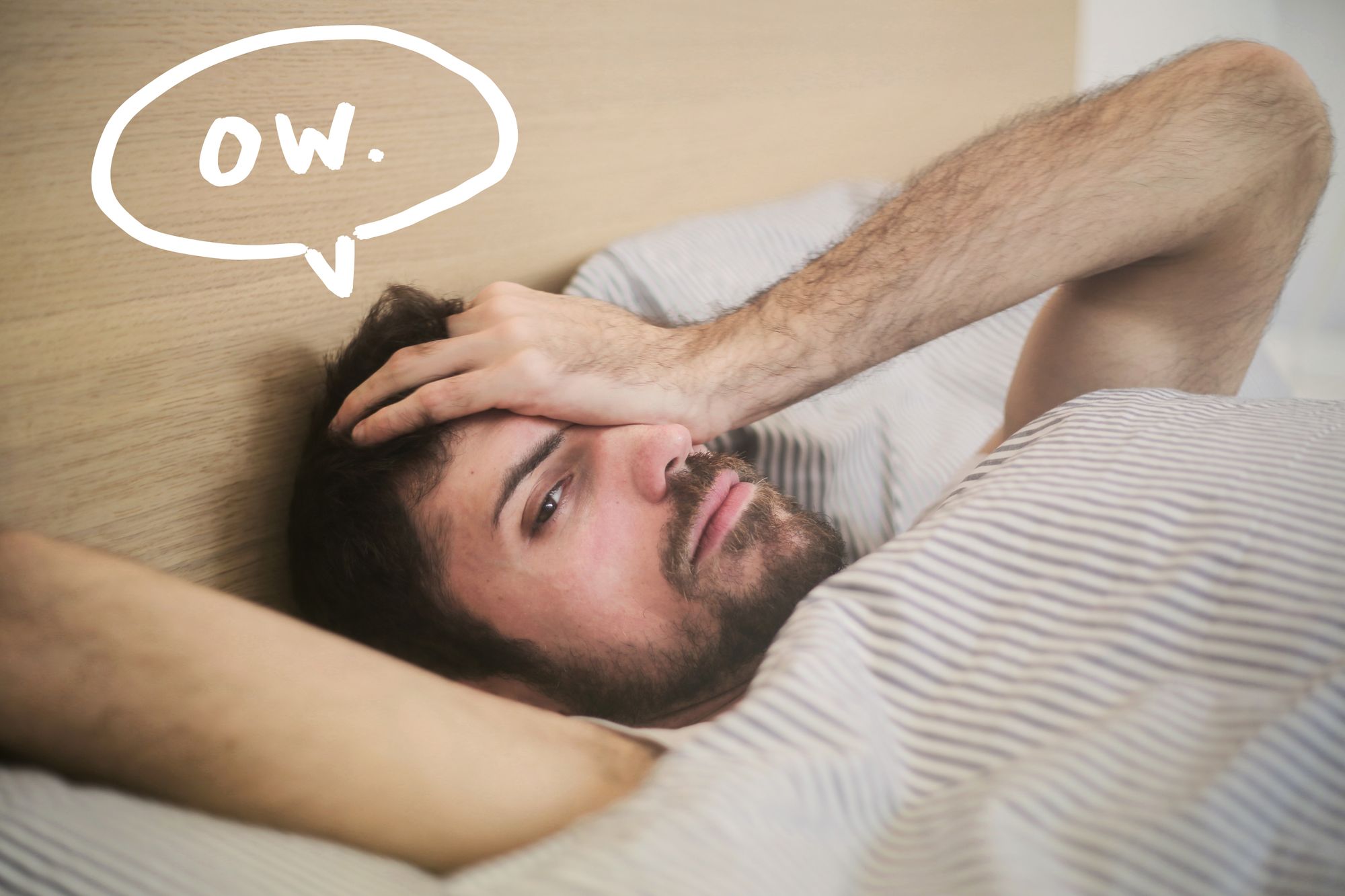 Man lying in bed with a headache