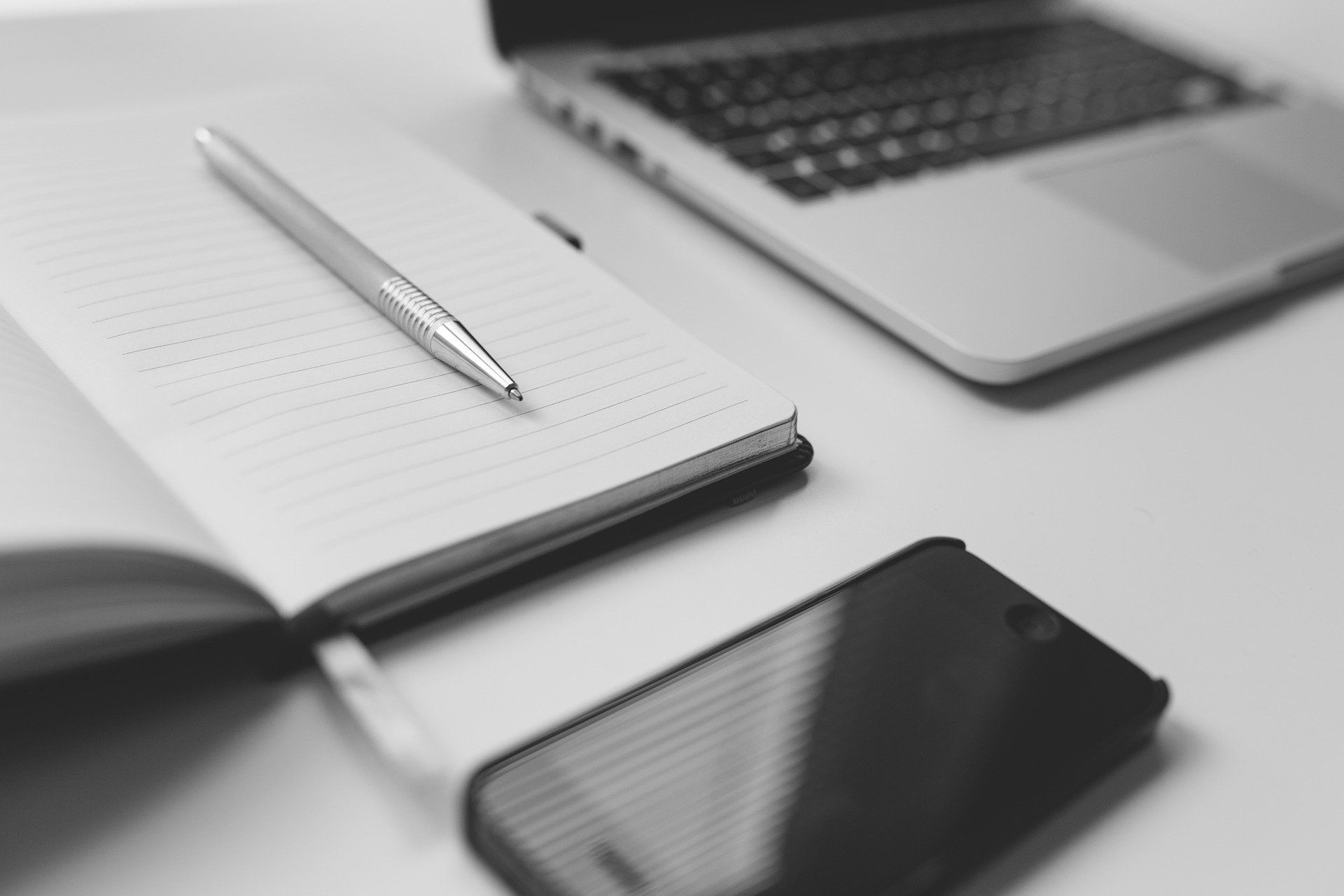 Notepad and pen on a desk with other language study tools