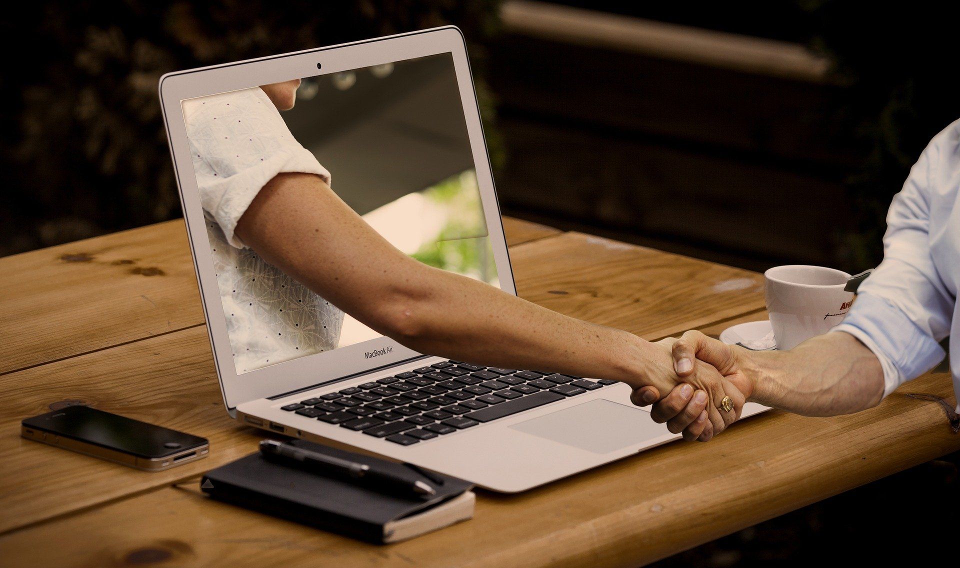 Hand shake through the laptop during online sales training