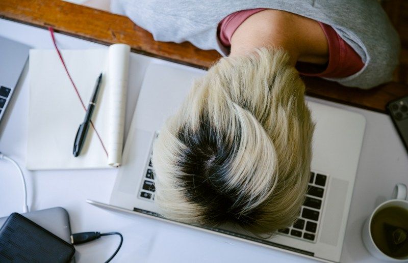 Frustrated man with head on desk; employee development