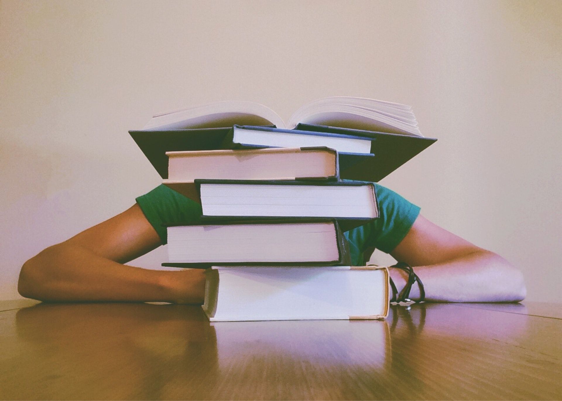 Student behind a stack of books; WSET 1 practice exam