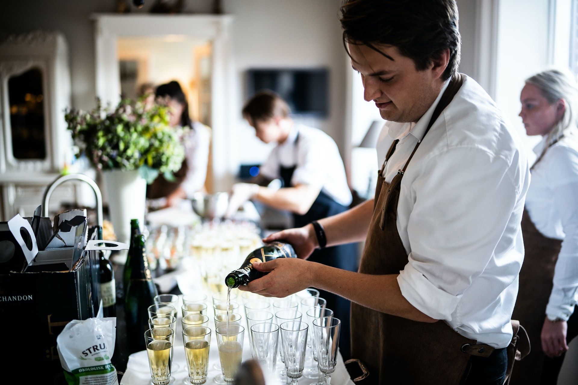 Waiter pouring champagne; WSET Level 1 exam