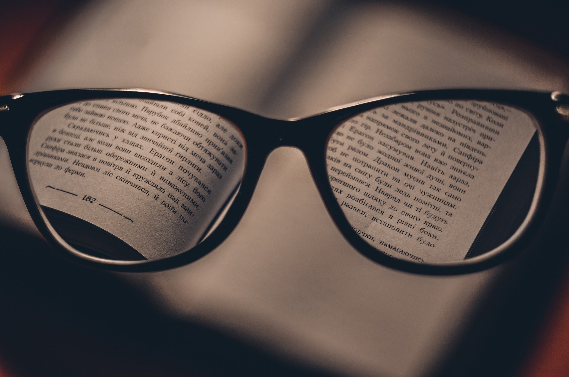 glasses showing the words clearly in a blurry book, bad vision fixed with glasses