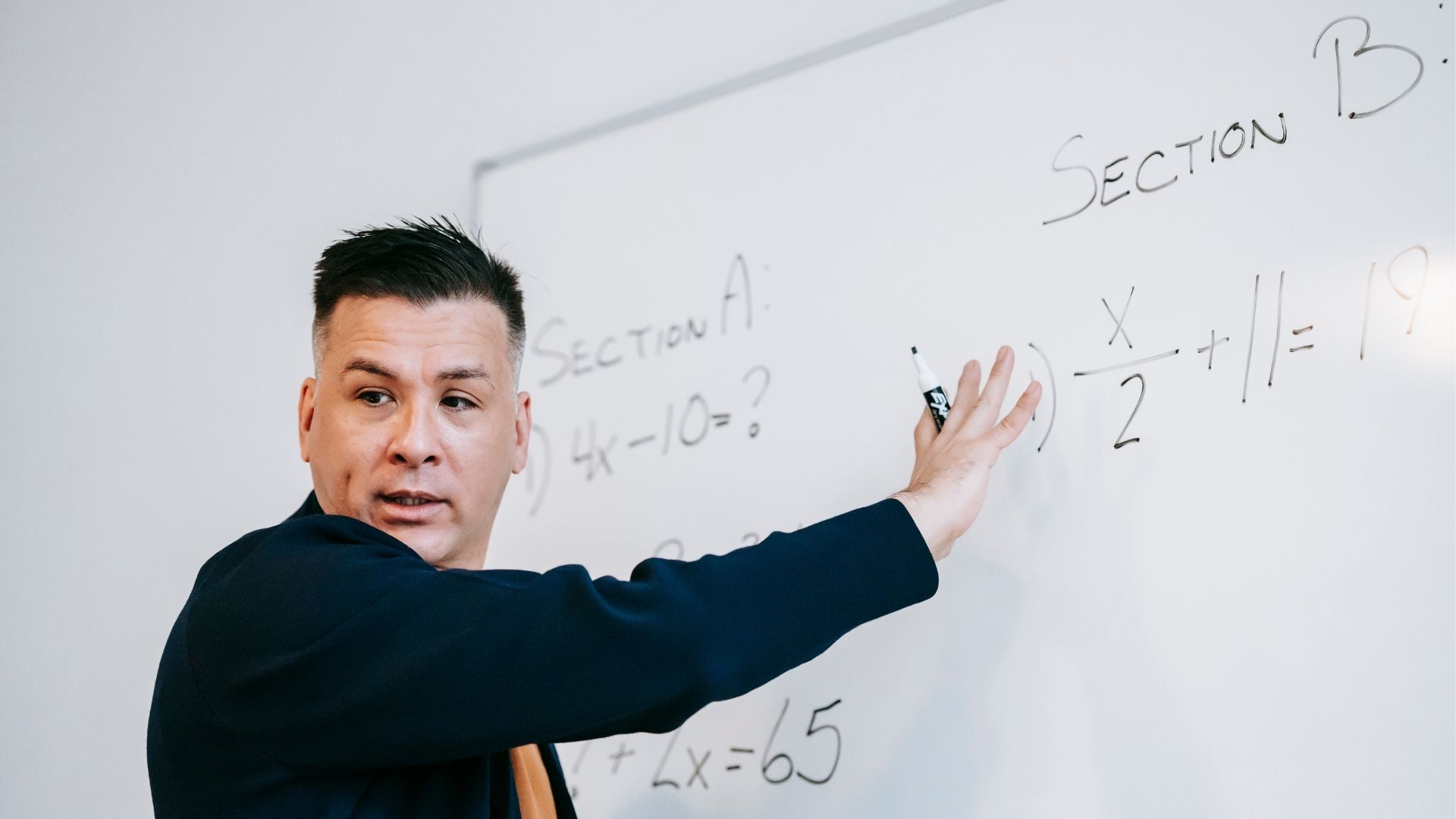 Professor in front of chalkboard saying important things before exam