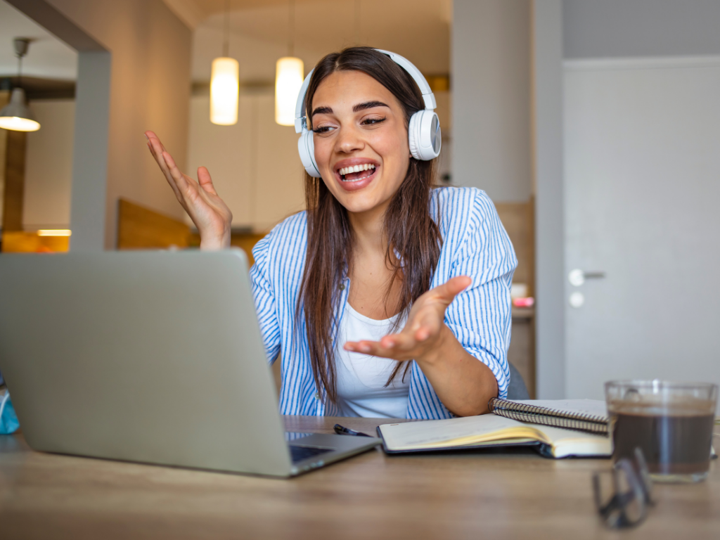 Girl with headphones in front of the computer working on her elearning business