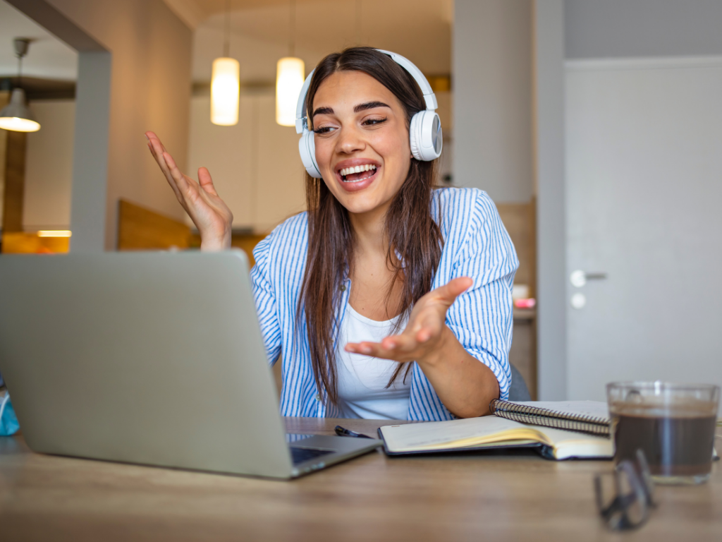 Chica con auriculares frente a la computadora trabajando en su negocio de elearning