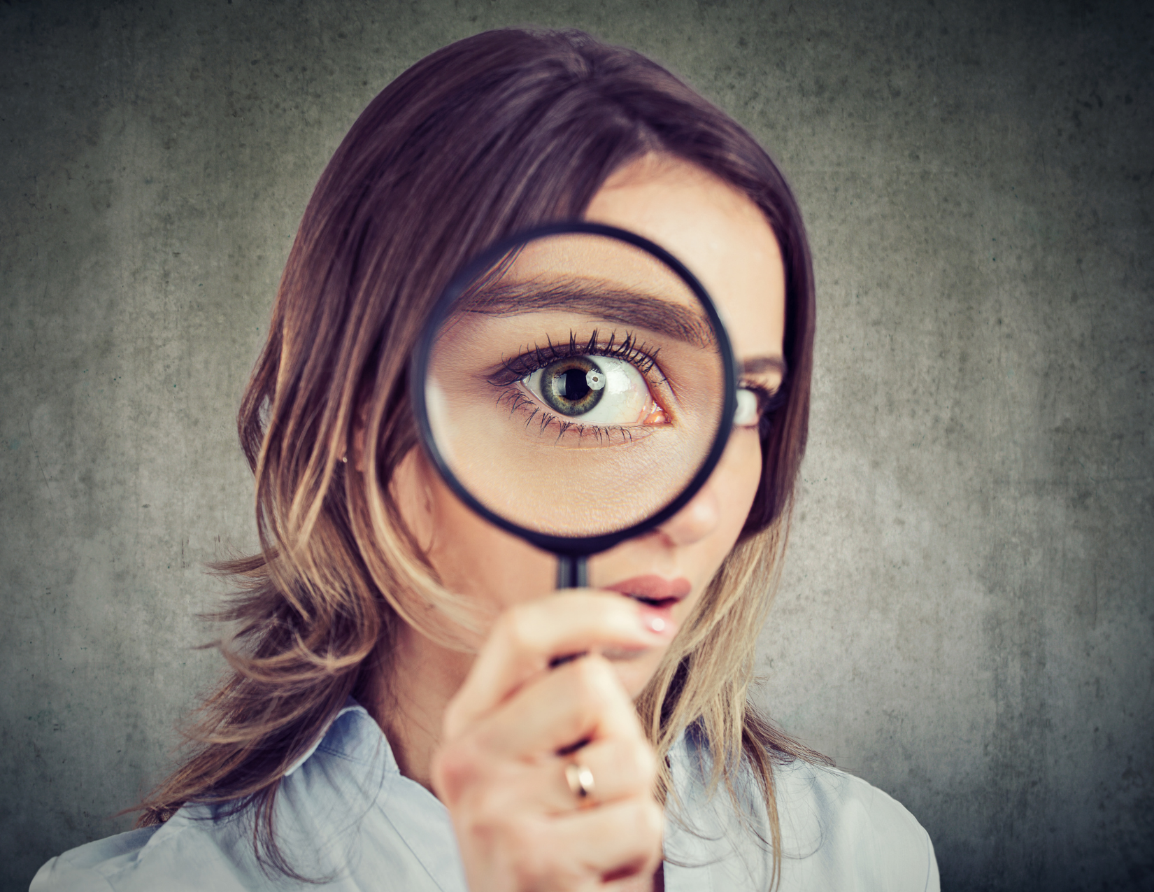 Lady looking with a magnifying glass; how to do well on the MCAT