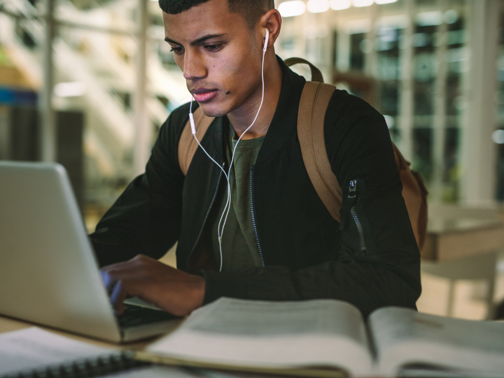 Hombre que estudia delante de la computadora portátil;  Cómo estudiar para el MCAT