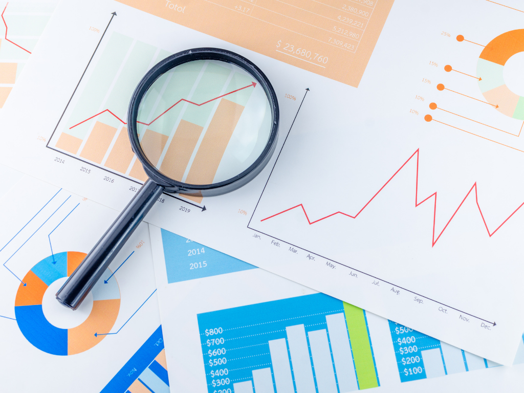 Papers and graphs with a magnifying glass; MCAT scores