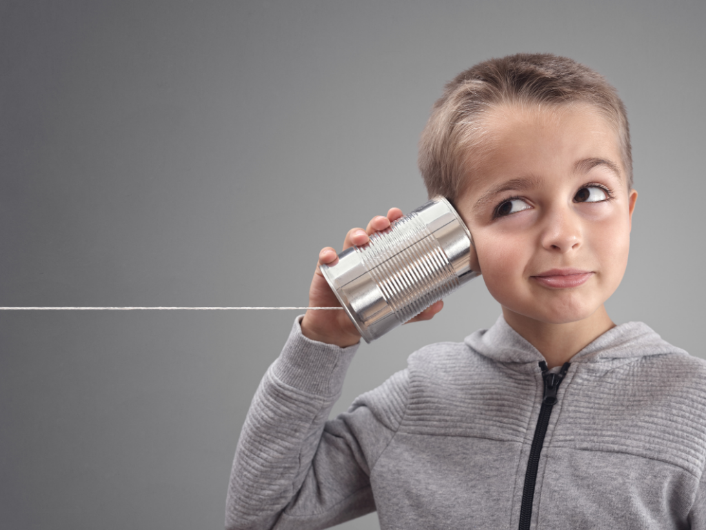 Kid listening through a tin can telephone