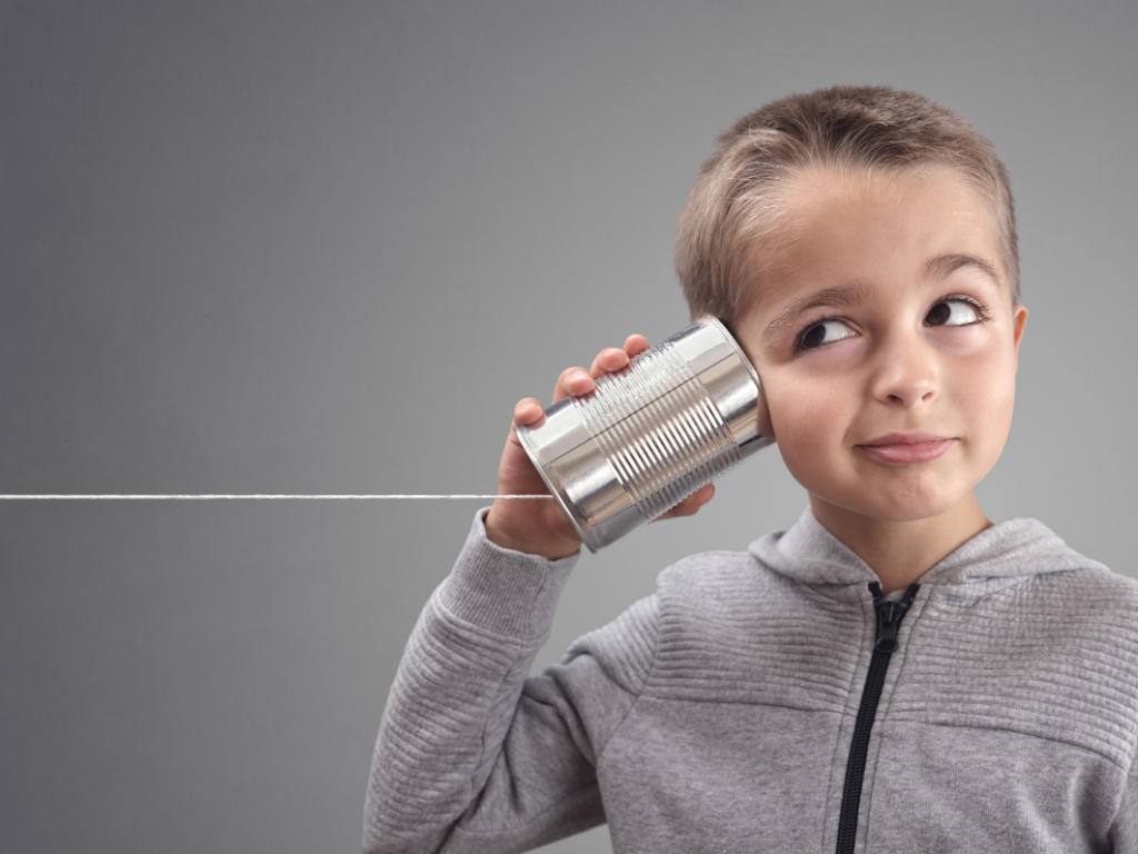 Niño escuchando a través de un teléfono de lata