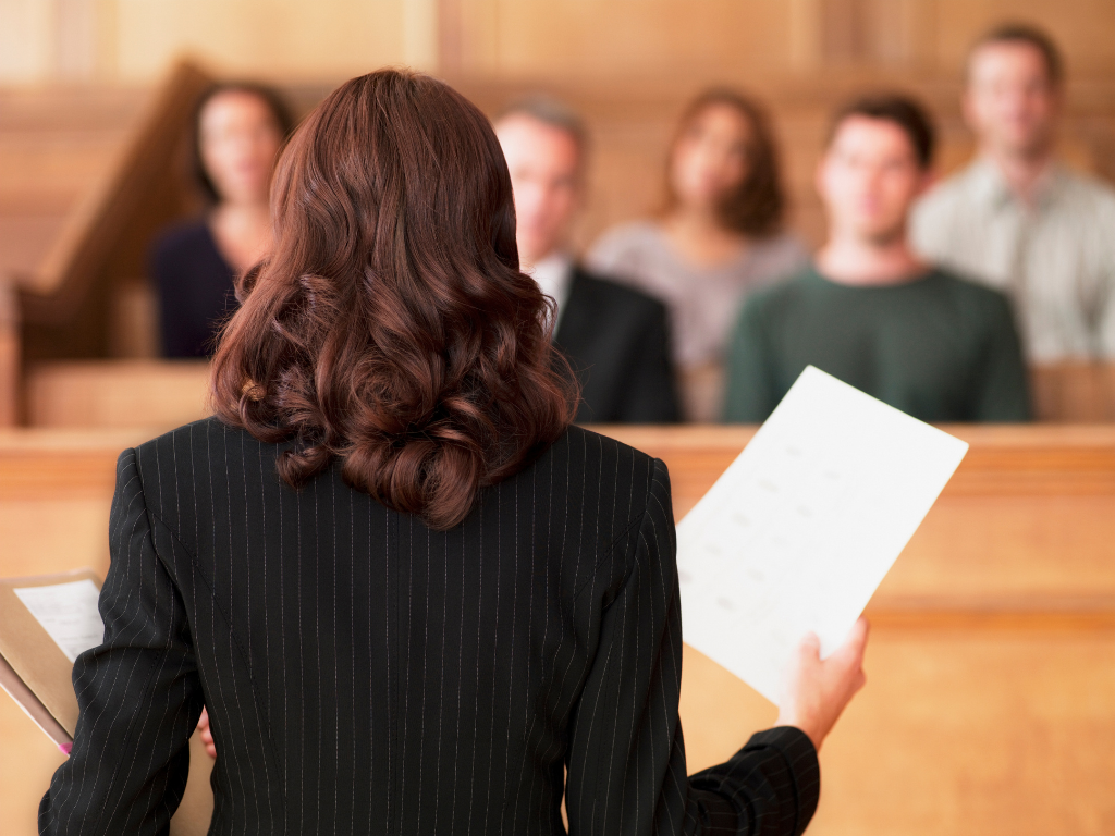 Female attorney practicing law in a courtroom in front of jury