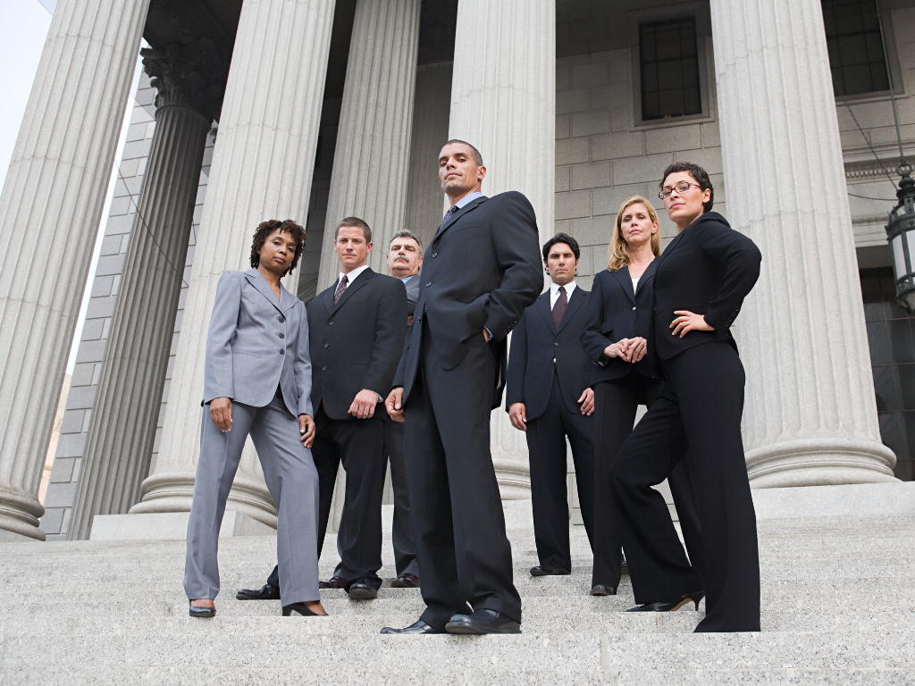 Group of lawyers in suits both males and females on the steps of a government building