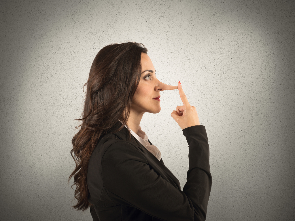 Woman touching the end of a long nose as a reminder not to lie in your law firm interview