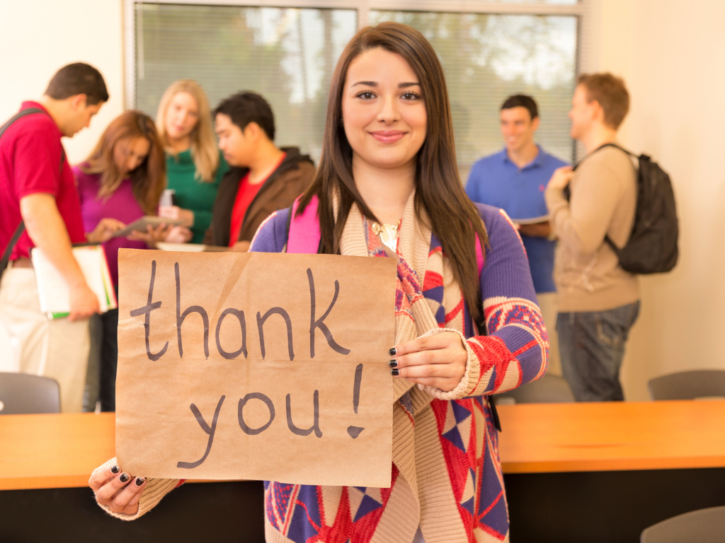 Student holding up a sign that says thank you