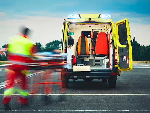 EMT and paramedic staff rushing patient into the back of an ambulance