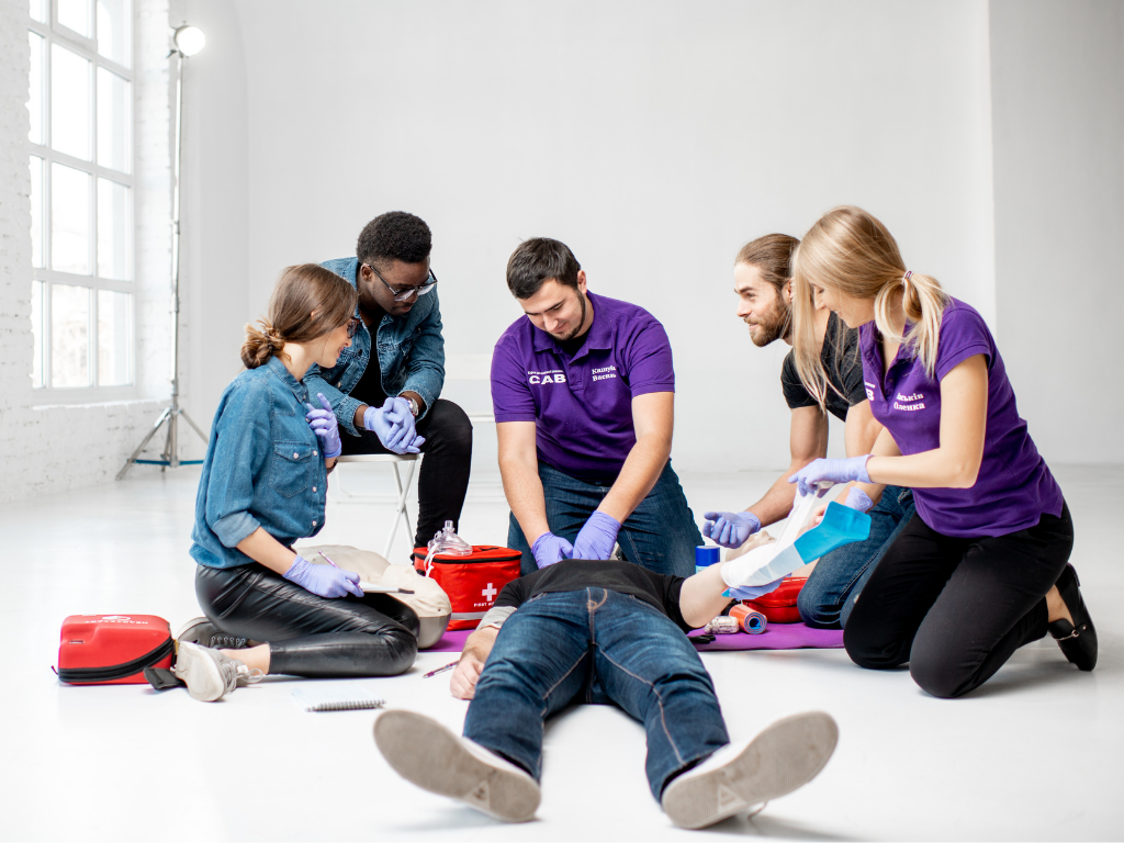 EMT students sitting around a patient performing various tests and tasks