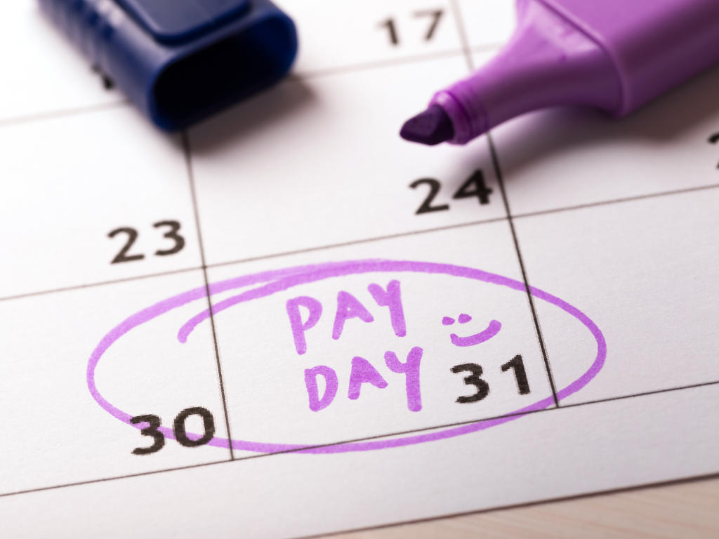 A calendar showing the 31st date with pay day written circled and a smiley face