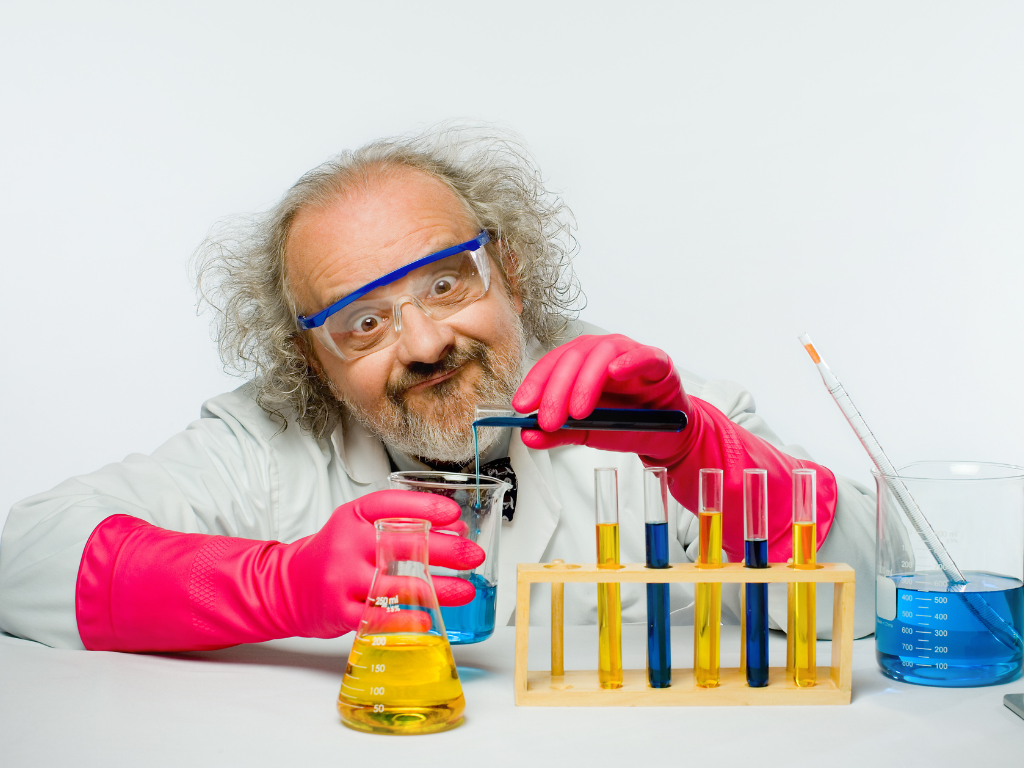 Scientest with pink gloves pouring a blue liquid from a test tube into a beaker