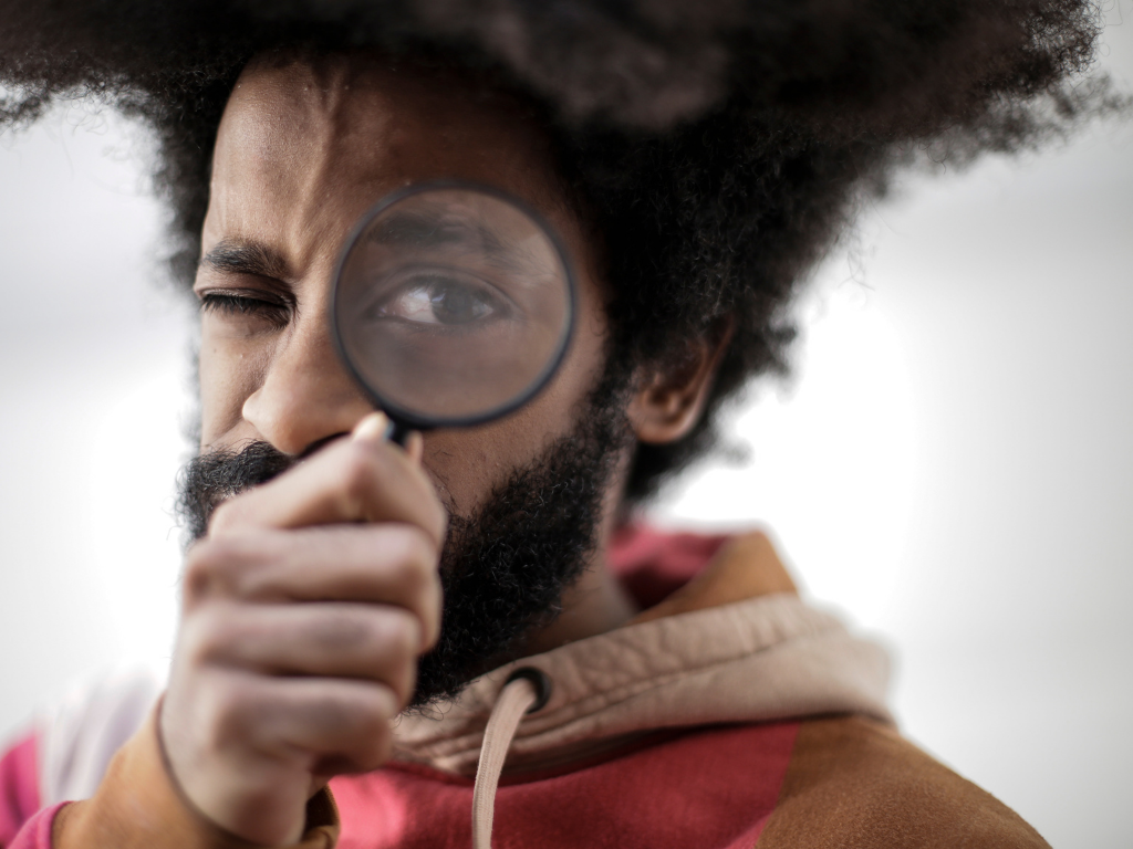 Man looking through a magnifying glass